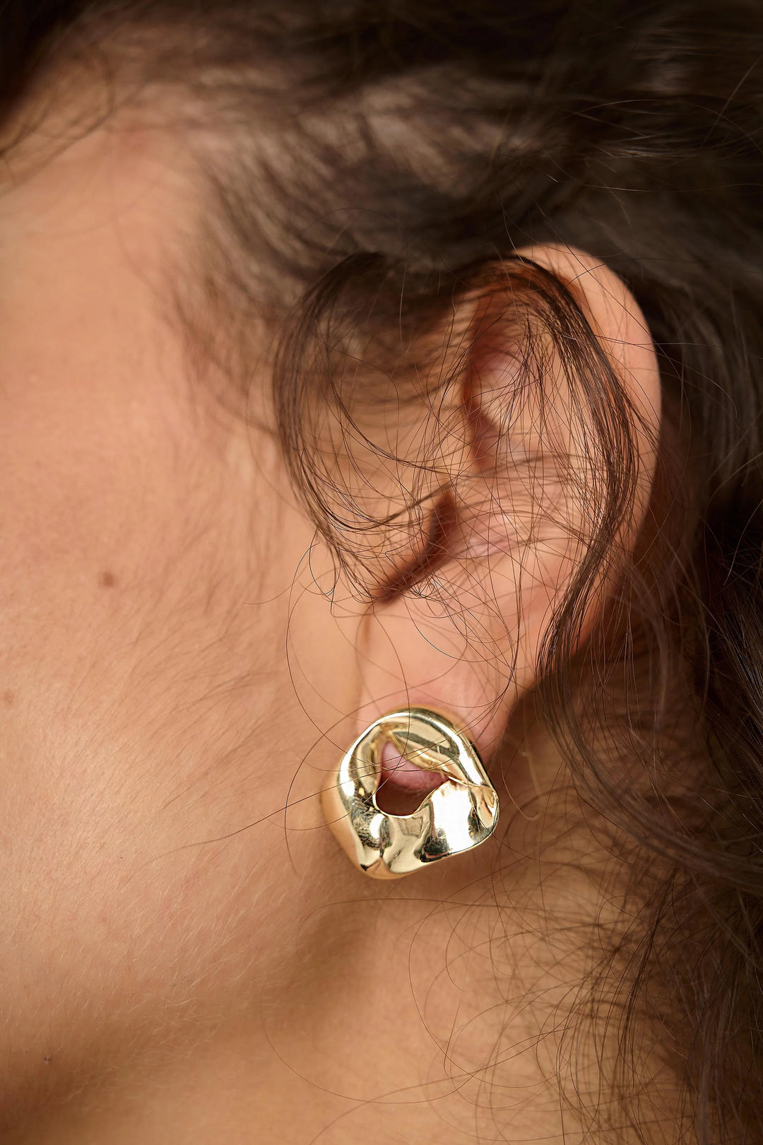 Tutti &amp; Co Soho earrings featuring gold hoops with intricate detailing, displayed on a jewelry stand.