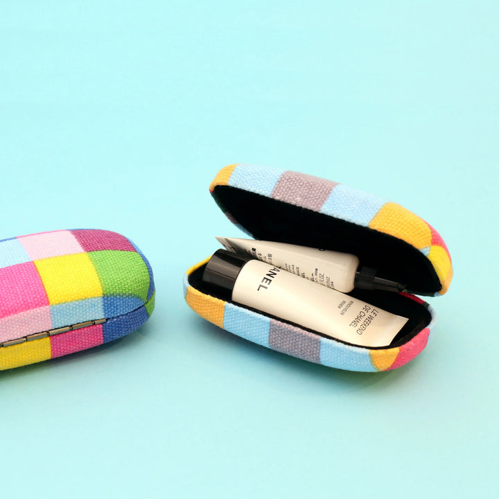 Kikkerland fabric travel case in assorted plaid pattern, compact and stylish for organizing travel essentials.