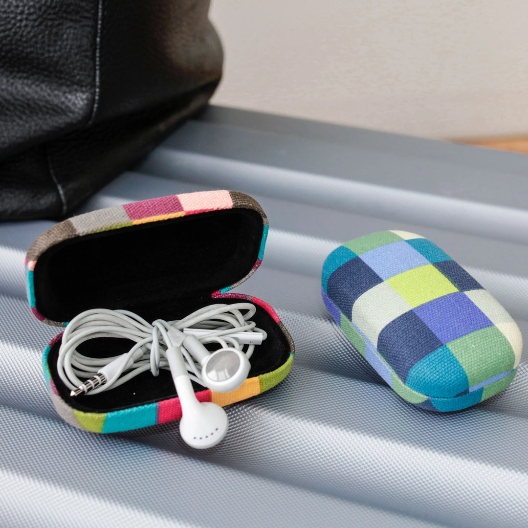 Kikkerland plaid fabric travel case with assorted colors, compact and portable for organizing travel essentials.
