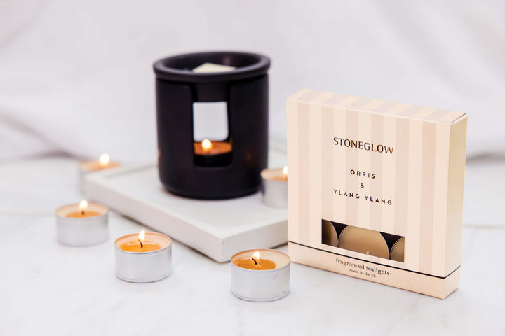 Stoneglow Orris &amp; Ylang Ylang scented tealights in a glass holder, creating a calming, aromatic ambiance for home decor.