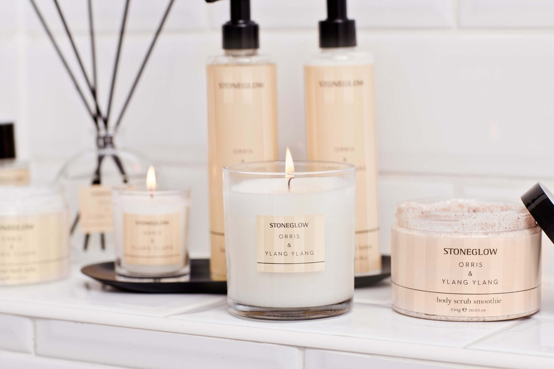 Stoneglow Modern Classics Oris and Ylang Ylang Candle in a stylish glass holder with floral accents and soft lighting.