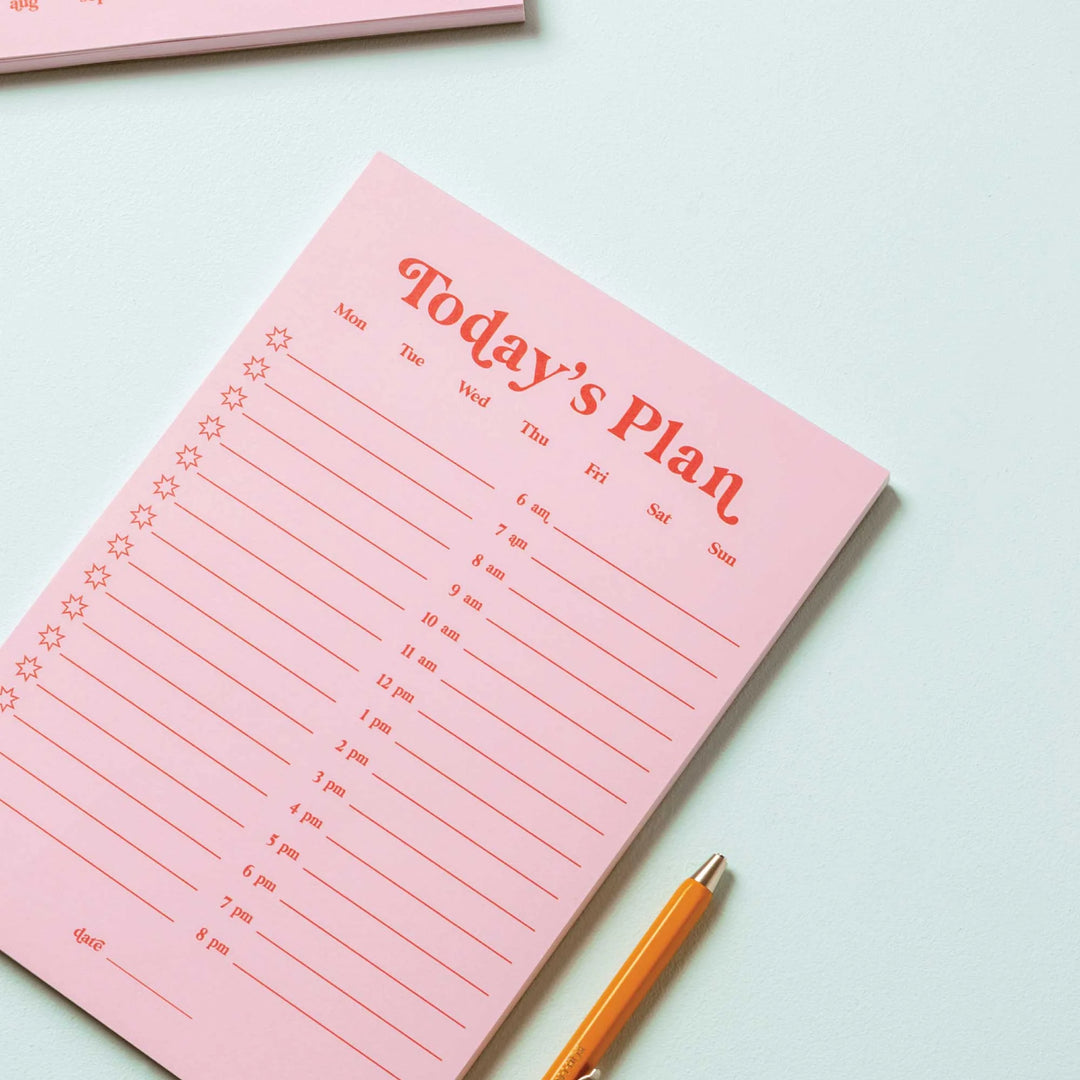 Pink and red A5 Daily Planner Pad by Good Tuesday from Cornucopia Home and Gift, with detailed pages for daily organization.