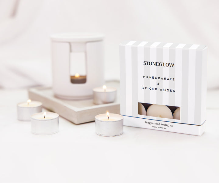 Stoneglow Pomegranate &amp; Spiced Woods scented tealights in decorative holders, perfect for cozy home ambiance.