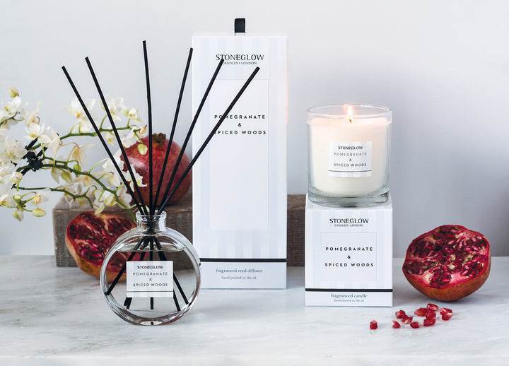 Stoneglow Pomegranate &amp; Spiced Woods scented tealights in glass holders, ideal for creating a warm, cozy ambiance.