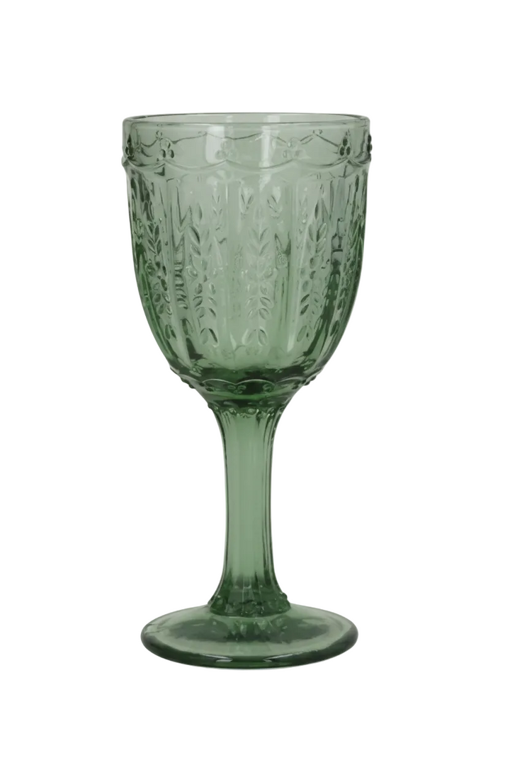 Green glass goblet with textured design on a white background