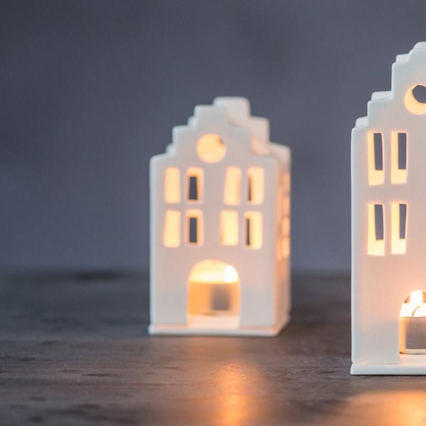 Small porcelain lighthouse by Radër from Cornucopia Home and Gift, featuring intricate details and a charming lighthouse design.