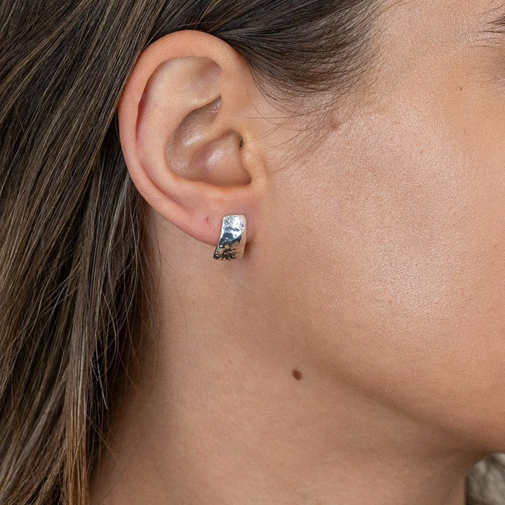Sterling silver hammered stud earrings from POM Jewellery by Cornucopia Home and Gift, featuring a textured, shiny finish.