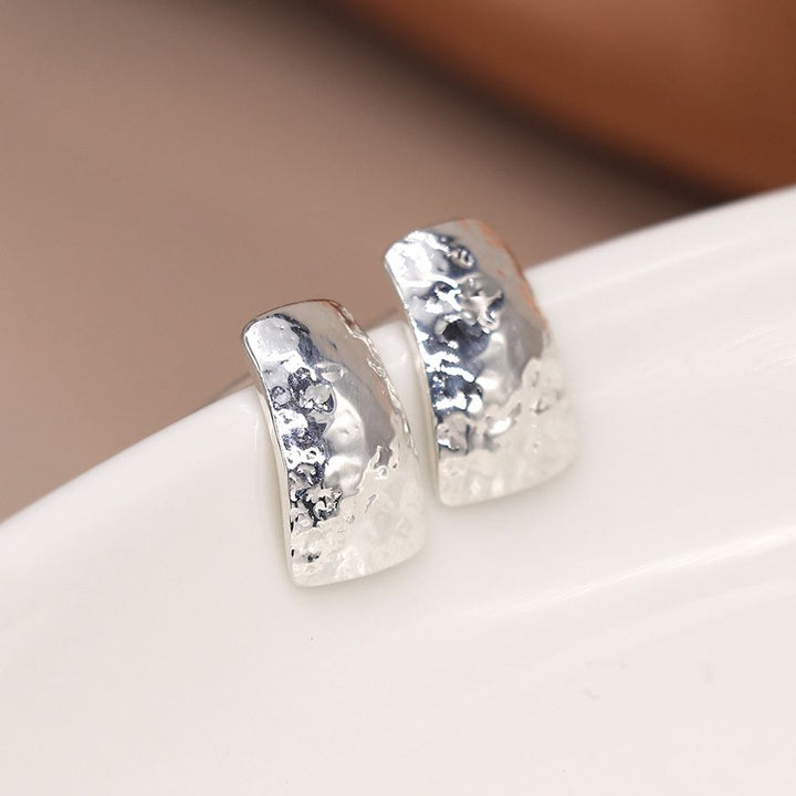 Sterling silver hammered stud earrings from POM Jewellery by Cornucopia Home and Gift, featuring a textured, shiny finish.
