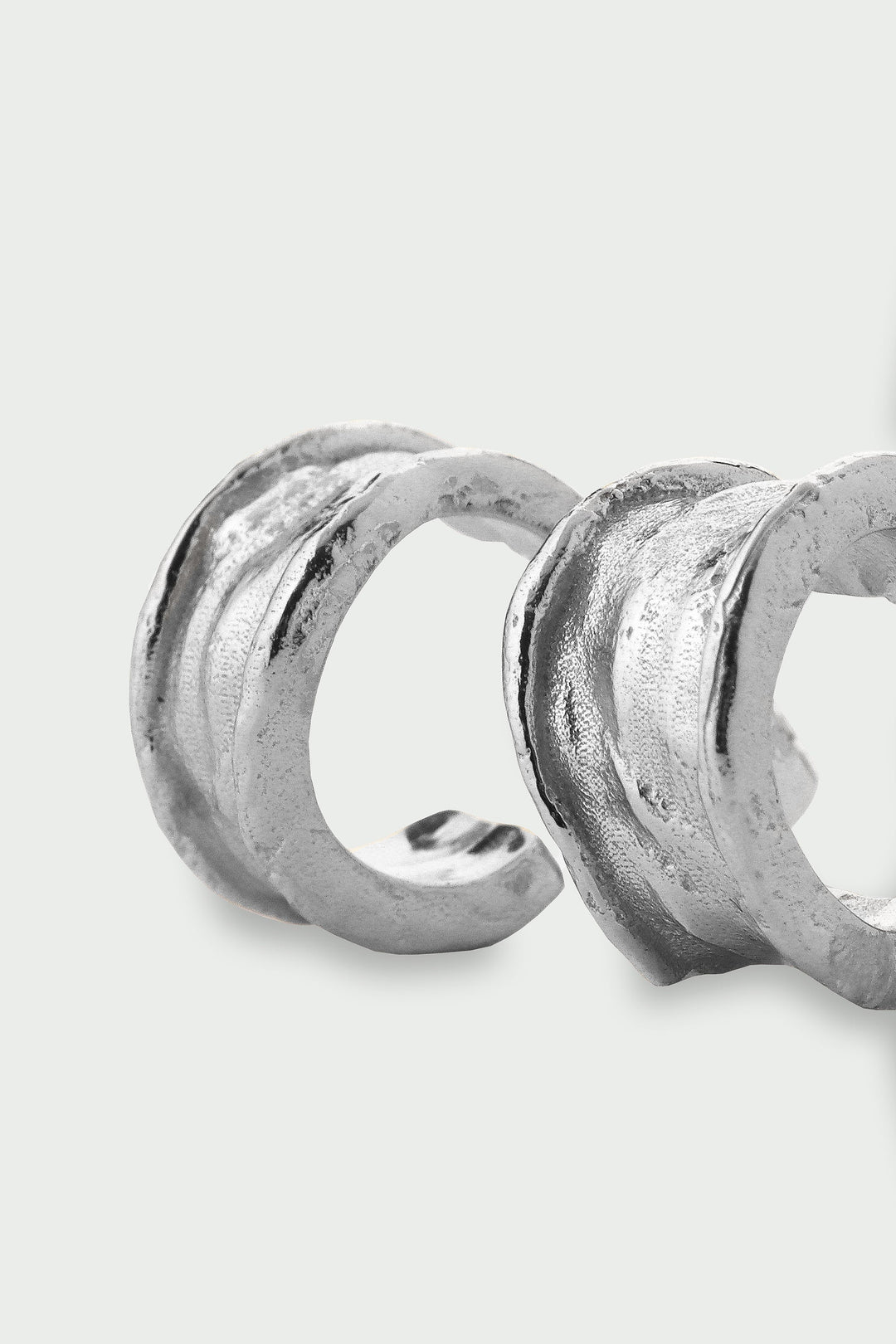 Silver Driftline Earrings by Tutti &amp; Co, shown hanging on a display with a sleek, modern design.