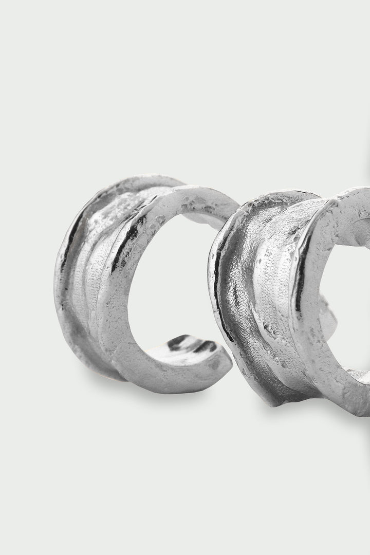 Silver Driftline Earrings by Tutti &amp; Co, shown hanging on a display with a sleek, modern design.