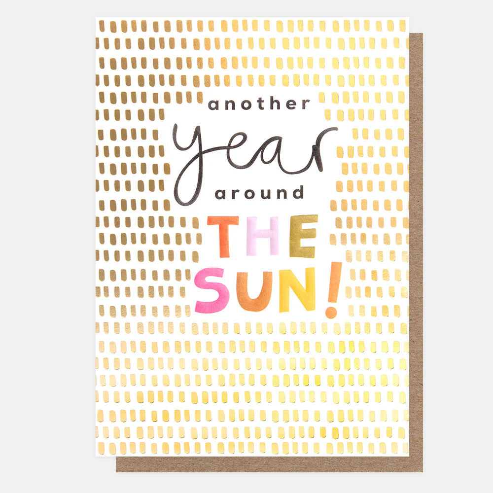 Gold patterned "Another Year Around the Sun" ceramic mug by Caroline Gardner, featuring sun and celestial design.