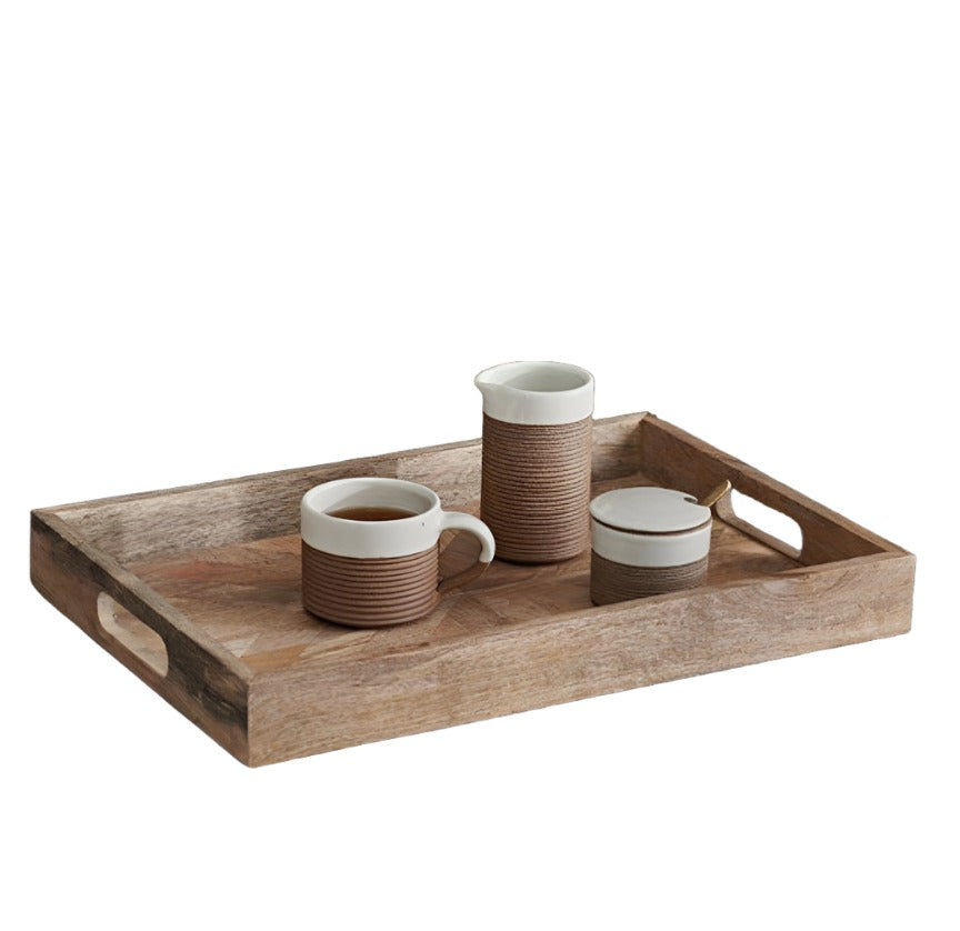 Rectangular Pawi Mango Wood Tray by Nkuku, featuring a natural wood finish with smooth edges and sturdy handles.