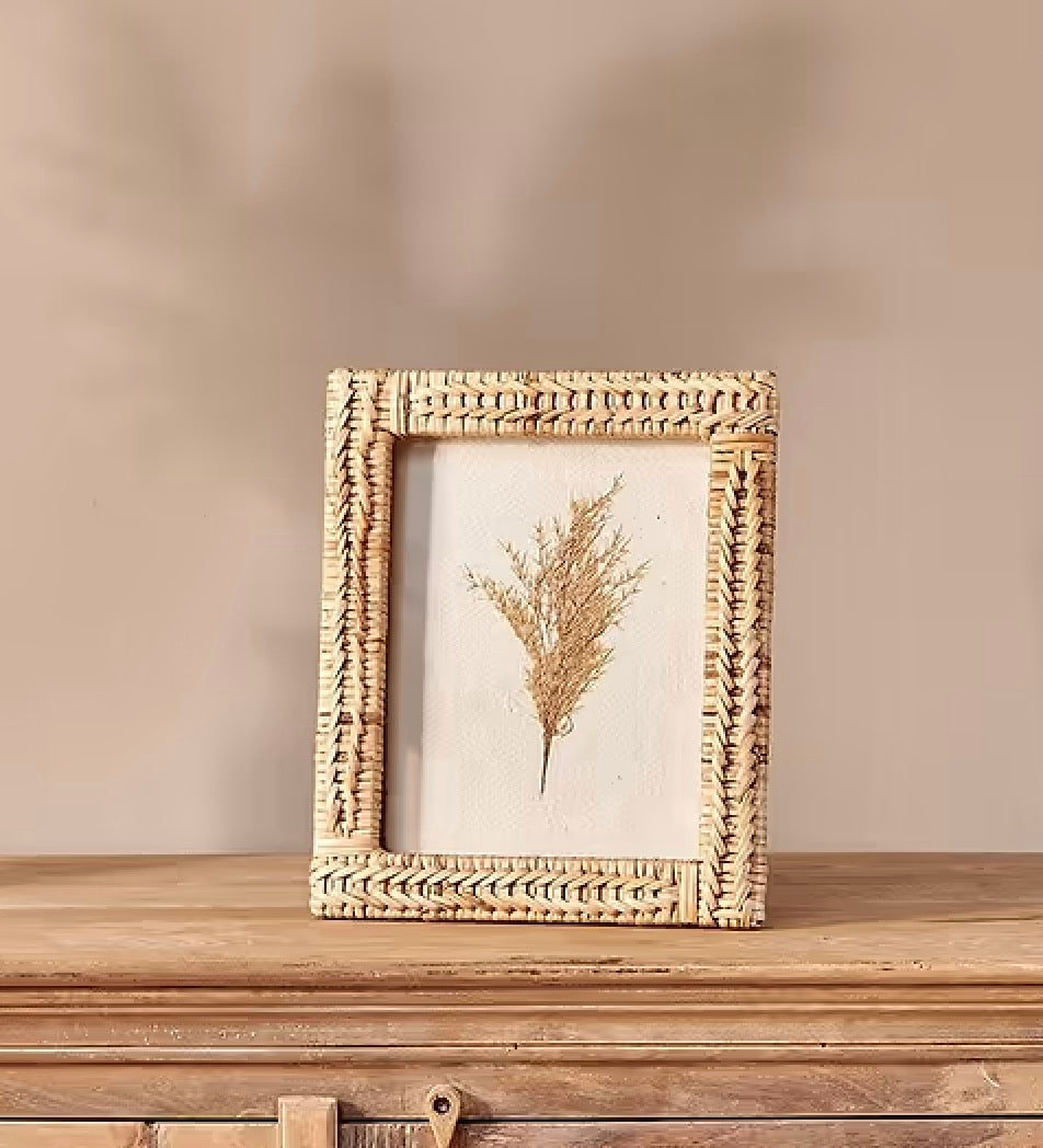 Rattan photo frame by Nkuku with a natural woven design, perfect for displaying cherished photographs in a stylish home decor setting.