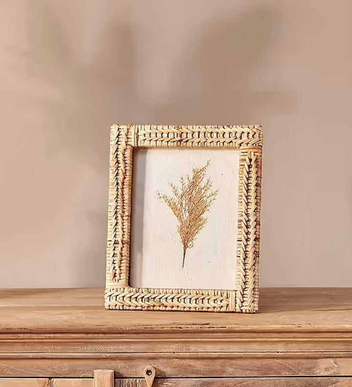 Rattan photo frame by Nkuku with a natural woven design, perfect for displaying cherished photographs in a stylish home decor setting.