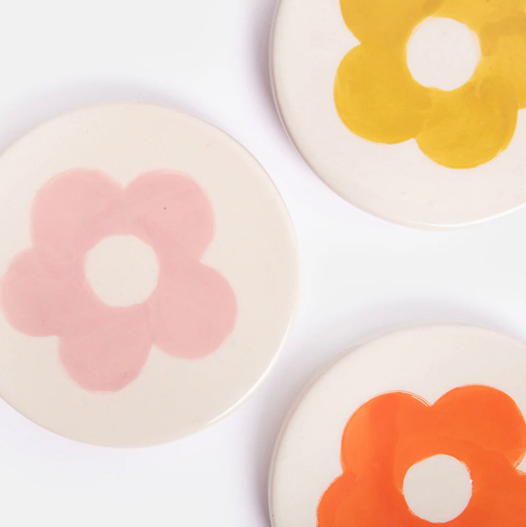 Set of four Caroline Gardner floral stoneware coasters with colorful botanical designs, perfect for protecting surfaces.