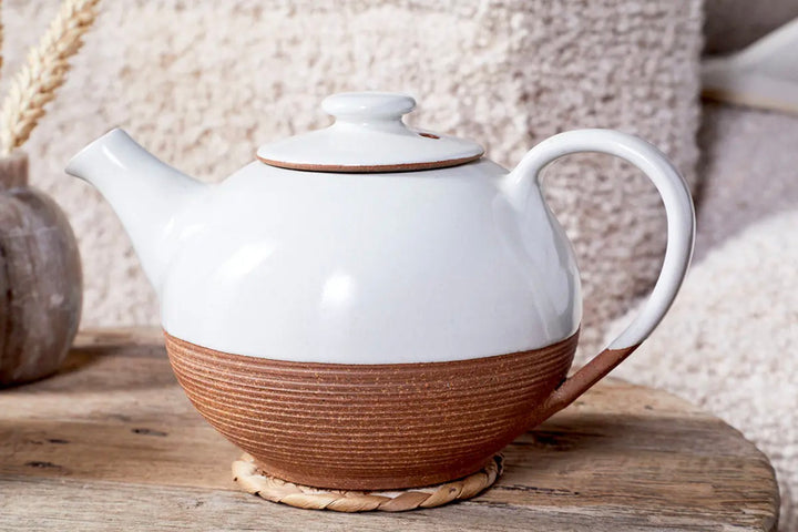 White and terracotta Mali ribbed teapot by Cornucopia Home and Gift, featuring a textured, rounded design with a spout and handle.