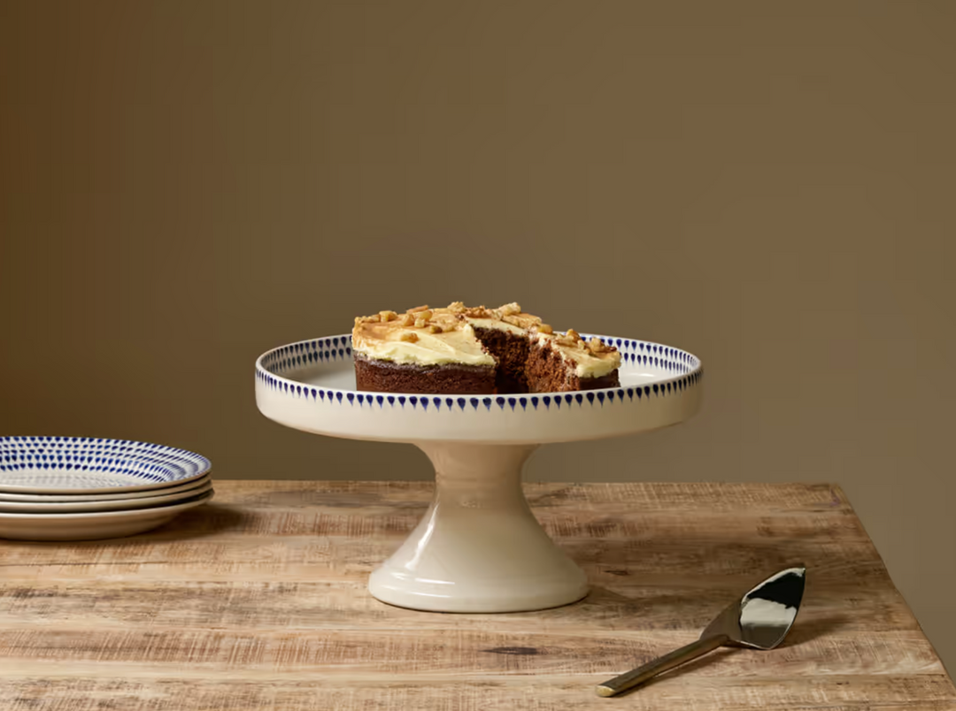 Nkuku Indigo Drop ceramic stand in cream and indigo, featuring a sleek, modern design perfect for displaying decorative items.