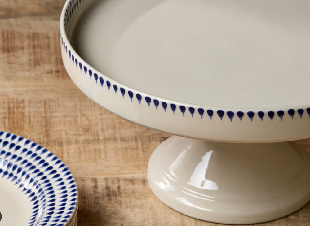 Nkuku Indigo Drop Ceramic Stand in cream and indigo glaze, featuring a sleek, modern design perfect for displaying decorative objects.