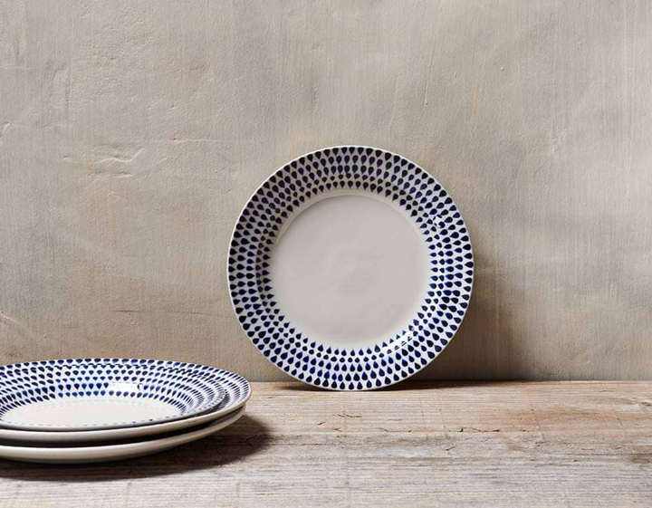 Indigo Drop Side Plate by Nkuku featuring a handcrafted ceramic design with blue drop accents.