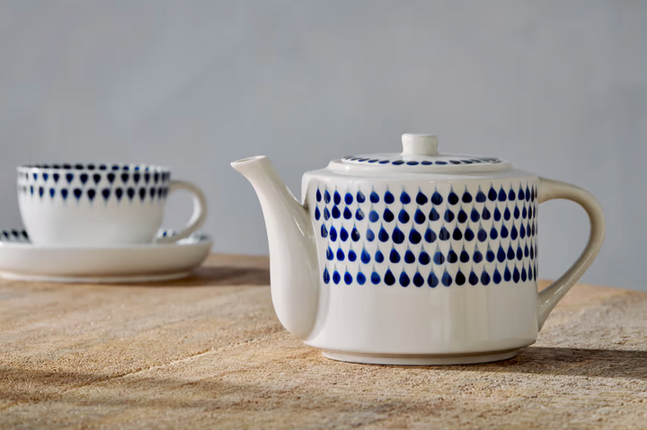 Indigo Drop Teapot by Nkuku featuring a stylish ceramic design with a rounded body and spout, perfect for serving tea.