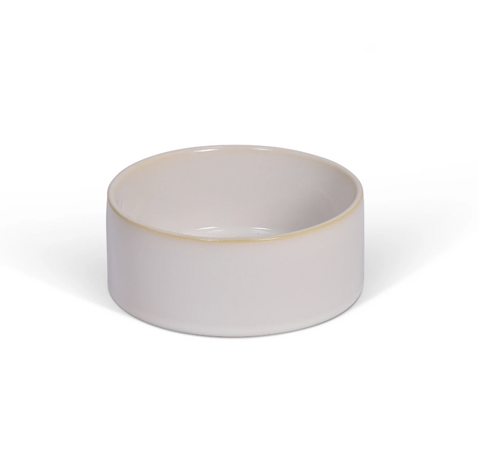White Toppesfield pet bowl by Garden Trading, made by Cornucopia Home and Gift, shown on a garden setting.