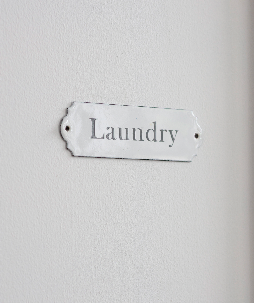 White enamel laundry sign with "Laundry" lettering from Garden Trading, designed by Cornucopia Home and Gift.