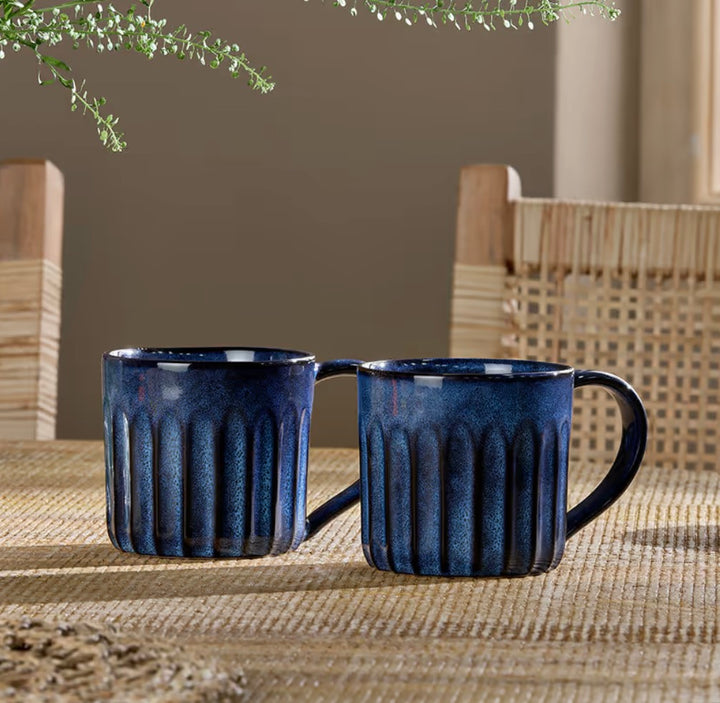 Set of two Nkuku Moda Deep Blue mugs with modern design, ideal for hot beverages, by Cornucopia Home and Gift.