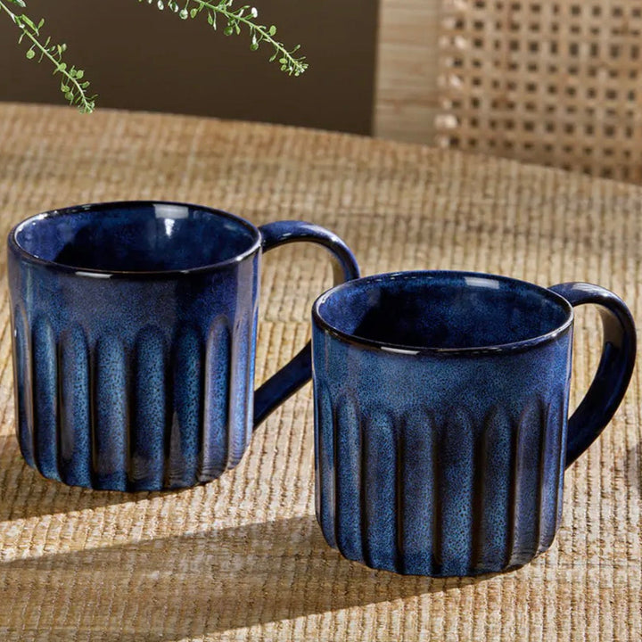 Set of two Nkuku Moda Deep Blue mugs with elegant design, perfect for coffee or tea, from Cornucopia Home and Gift.