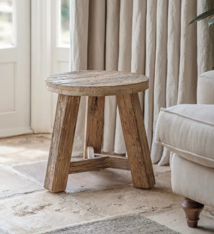 Nkuku Ibo reclaimed wood round side table in natural finish, featuring a rustic, handcrafted design with sturdy wooden legs.