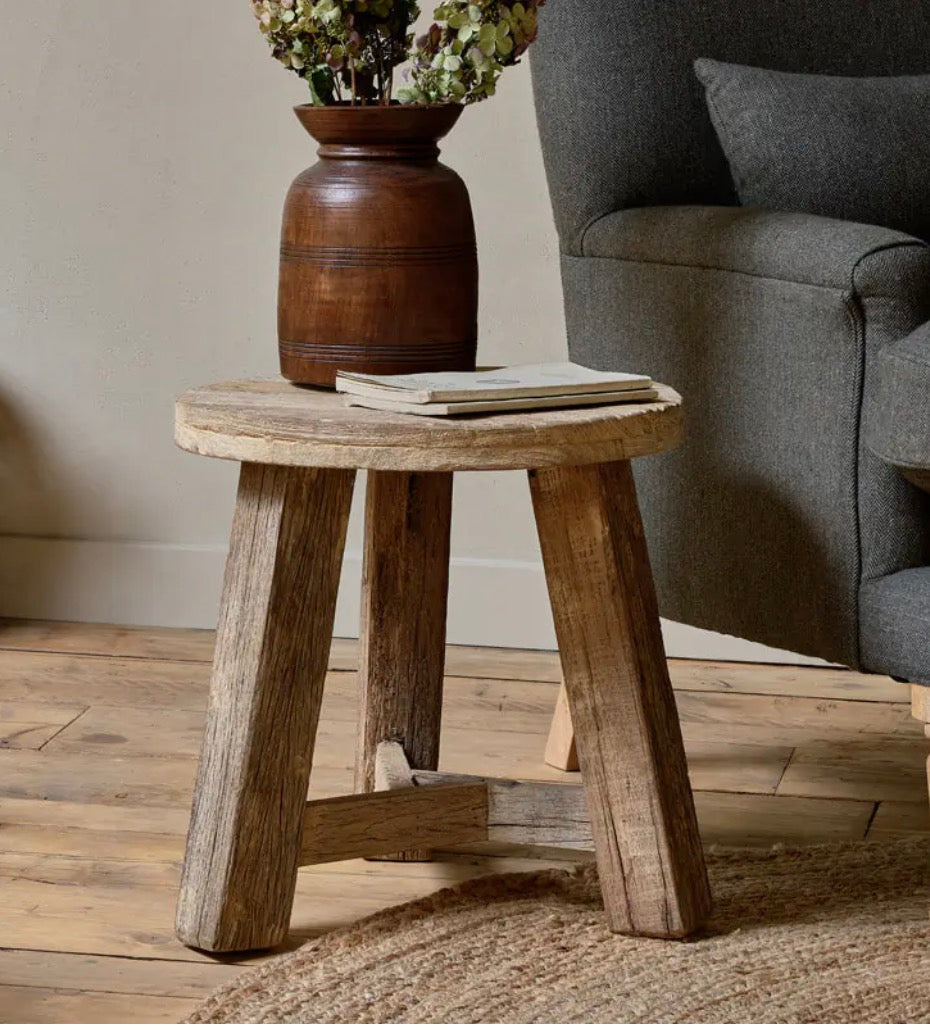Nkuku Ibo reclaimed wood round side table in natural finish, showcasing smooth wooden surface and sturdy base for living room decor.