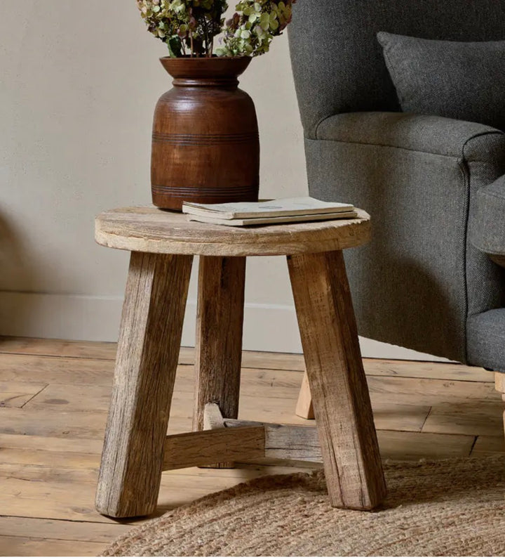 Nkuku Ibo reclaimed wood round side table in natural finish, showcasing smooth wooden surface and sturdy base for living room decor.