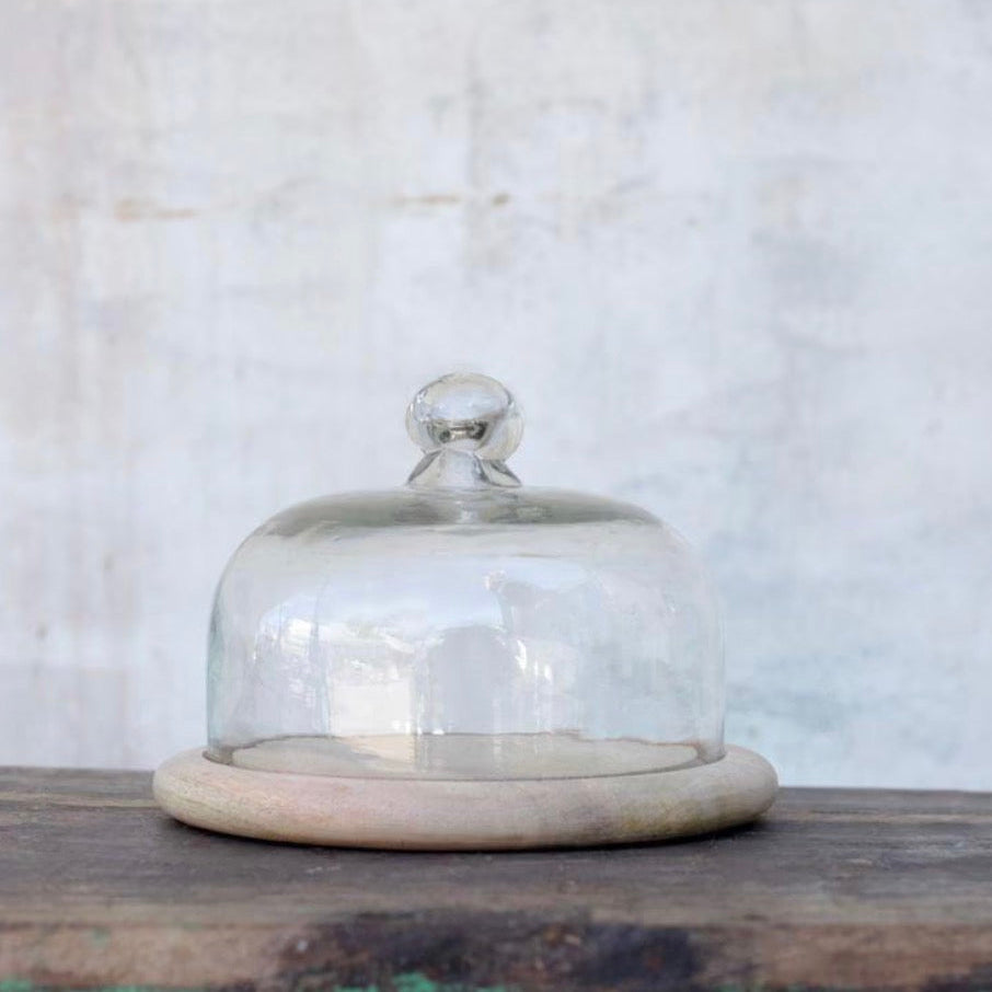 Clear recycled glass cake dome by Nkuku, showcasing a stylish and eco-friendly cover for desserts and baked goods.