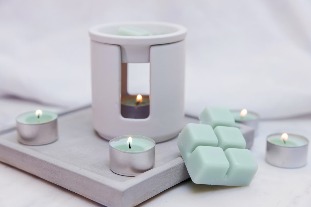 Sea Salt &amp; Oakmoss scented tealights from Stoneglow, displayed in a cozy home setting with flickering flames.