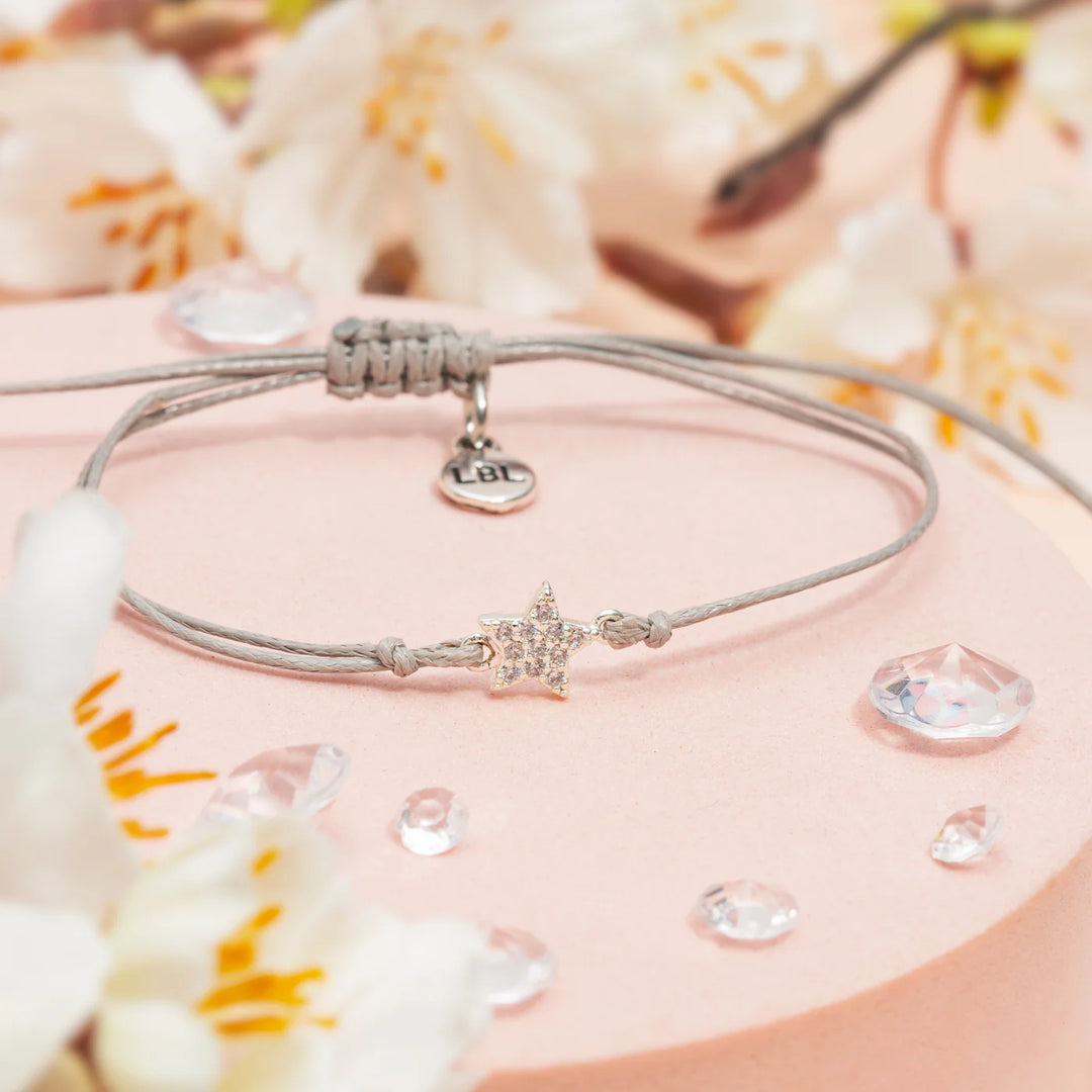 Close-up of a gold positivity sentiment bracelet with star charm, from Letterbox Love by Cornucopia Home and Gift.