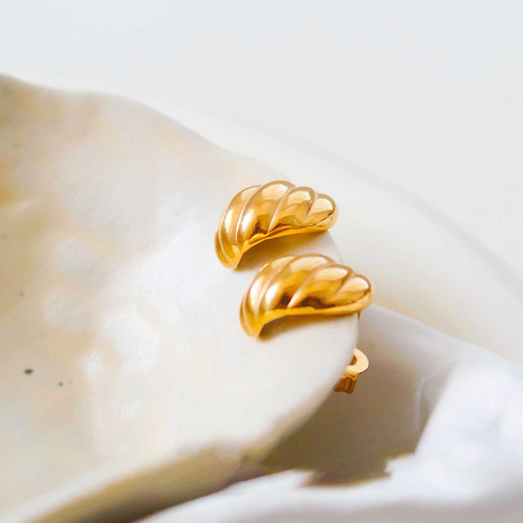 White leaf-shaped Gold Twisted Curve Earrings with a sleek, elegant design from Cornucopia Home and Gift.