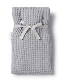 Grey Bailey hot water bottle by Cornucopia Home and Gift, shown with a cozy cover and textured fabric.