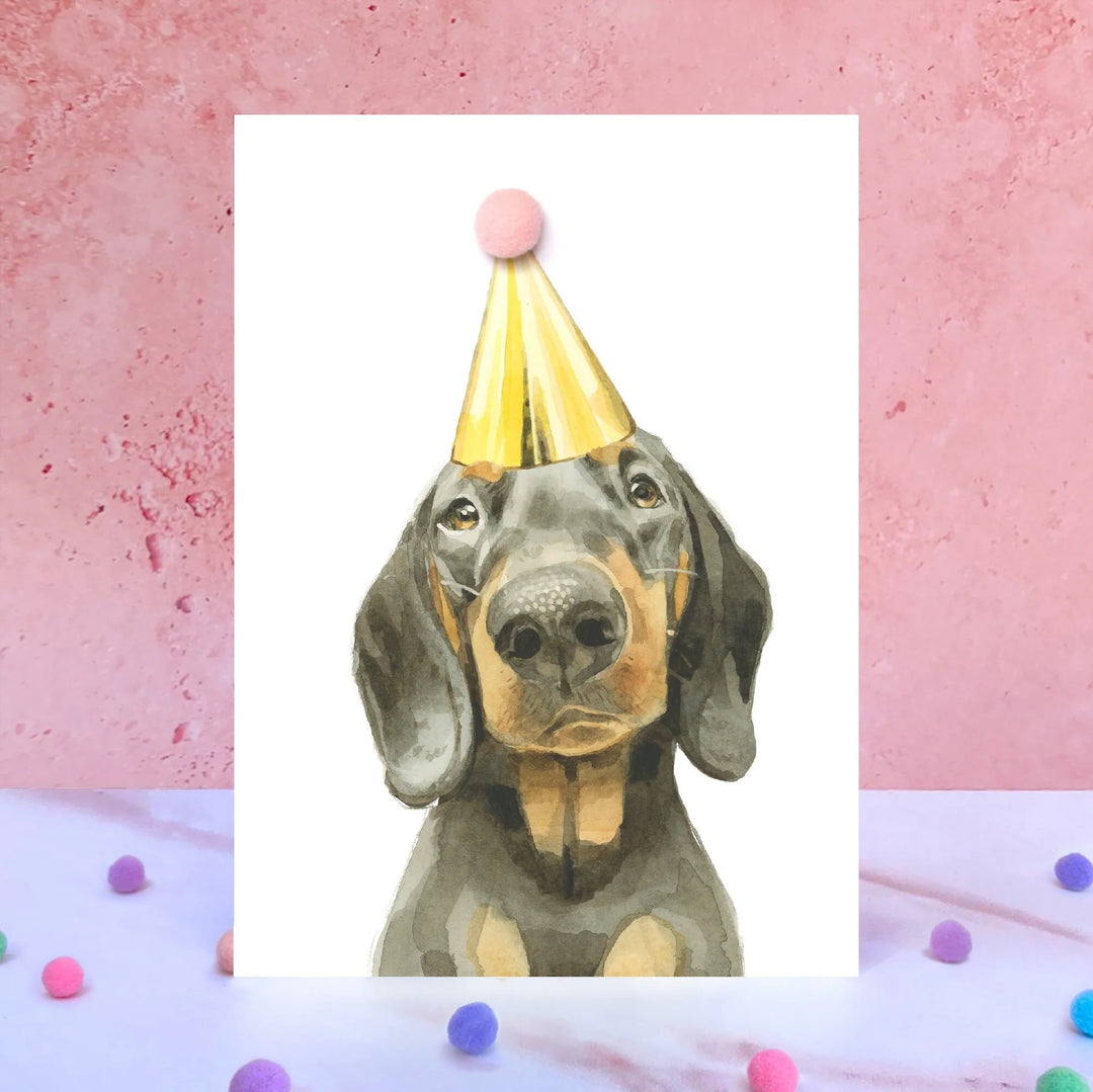 Dachshund pompom birthday card by Robert James Hull featuring a cute dog design, ideal for celebrating birthdays.