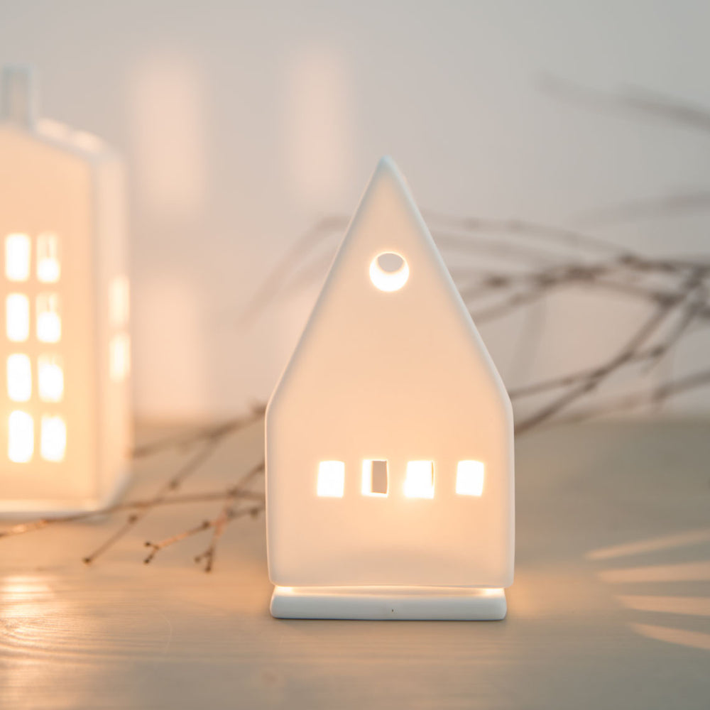 Small porcelain lighthouse ornament by Räder, featuring intricate details and a classic coastal design from Cornucopia Home and Gift.