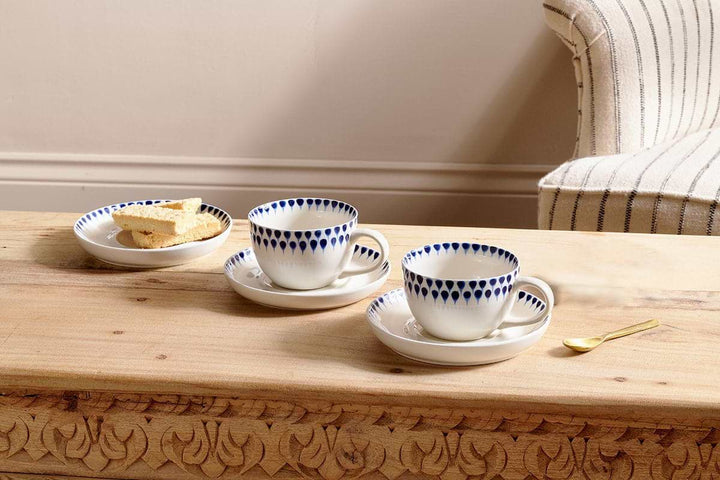 Indigo Drop Cup and Saucer by Nkuku, featuring a handcrafted ceramic design with a glossy finish on a white background.