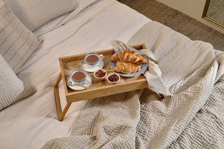 Nkuku Pawi mango wood breakfast tray with handles, natural finish, ideal for serving breakfast or tea in a stylish setting.
