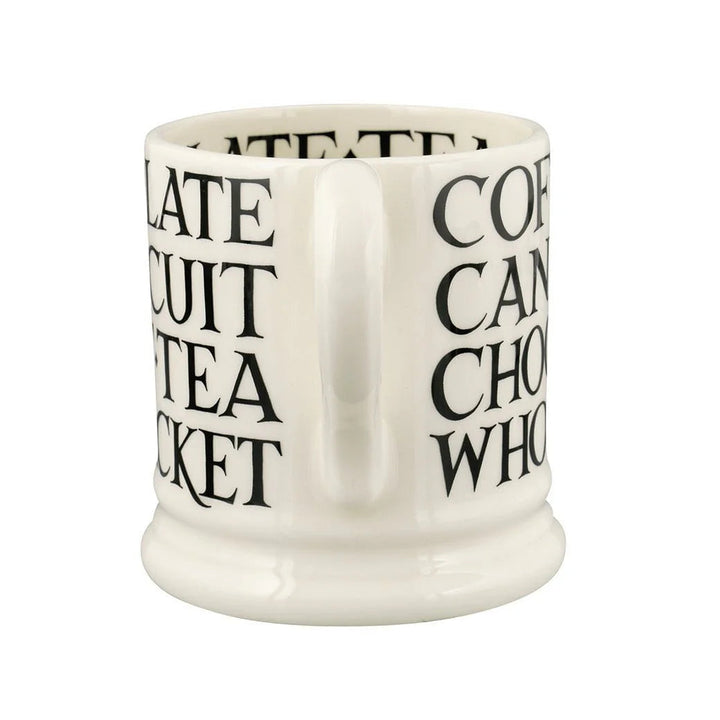 Emma Bridgewater Black Toast all-over writing 1/2 pint mug with black toast pattern on white ceramic, displayed on a wooden surface.