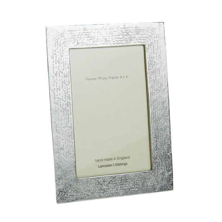 Silver photo frame with textured surface on a gray background