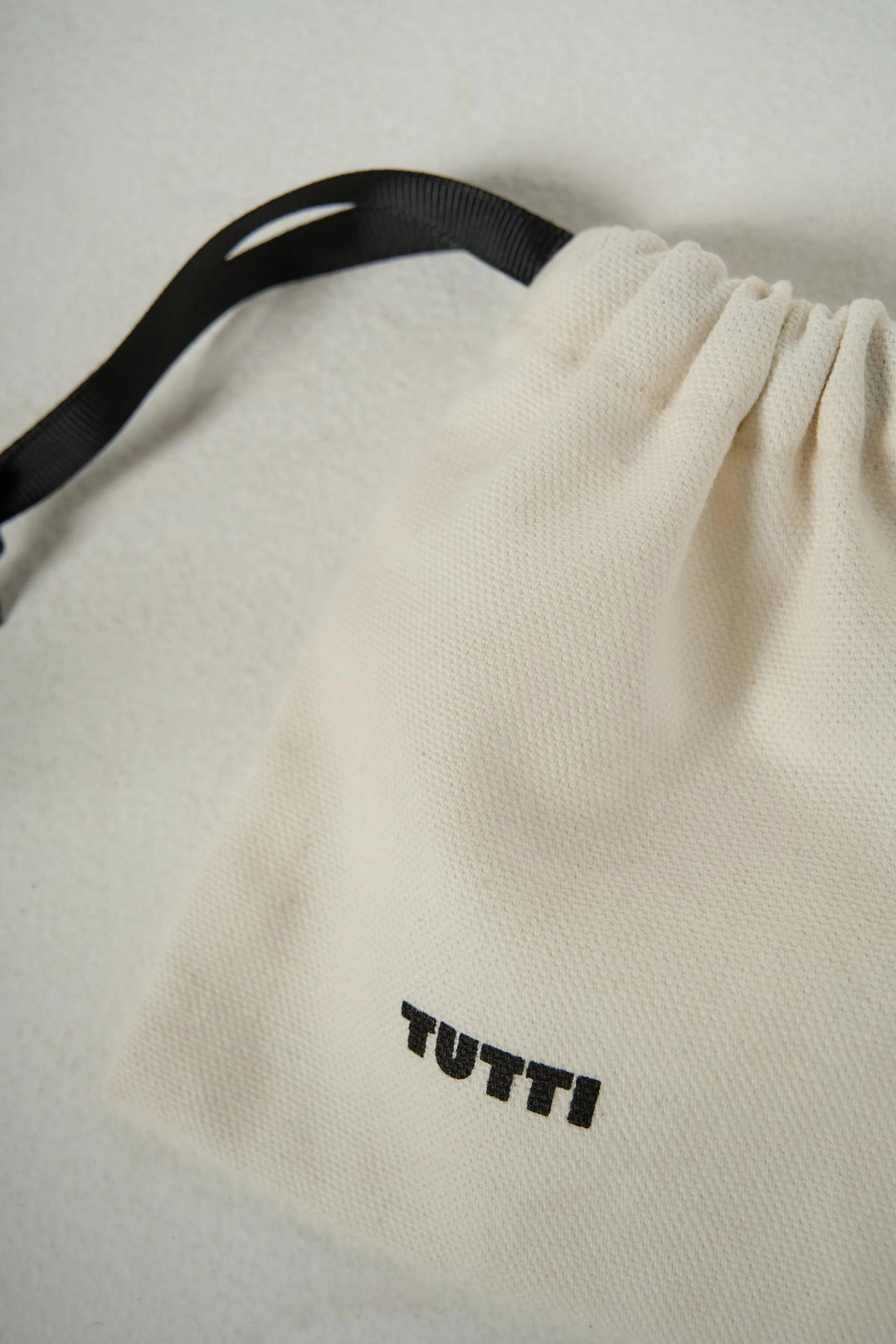 Gold Halo Necklace by Tutti &amp; Co displayed in a soft pouch, showcasing its elegant circular pendant design.