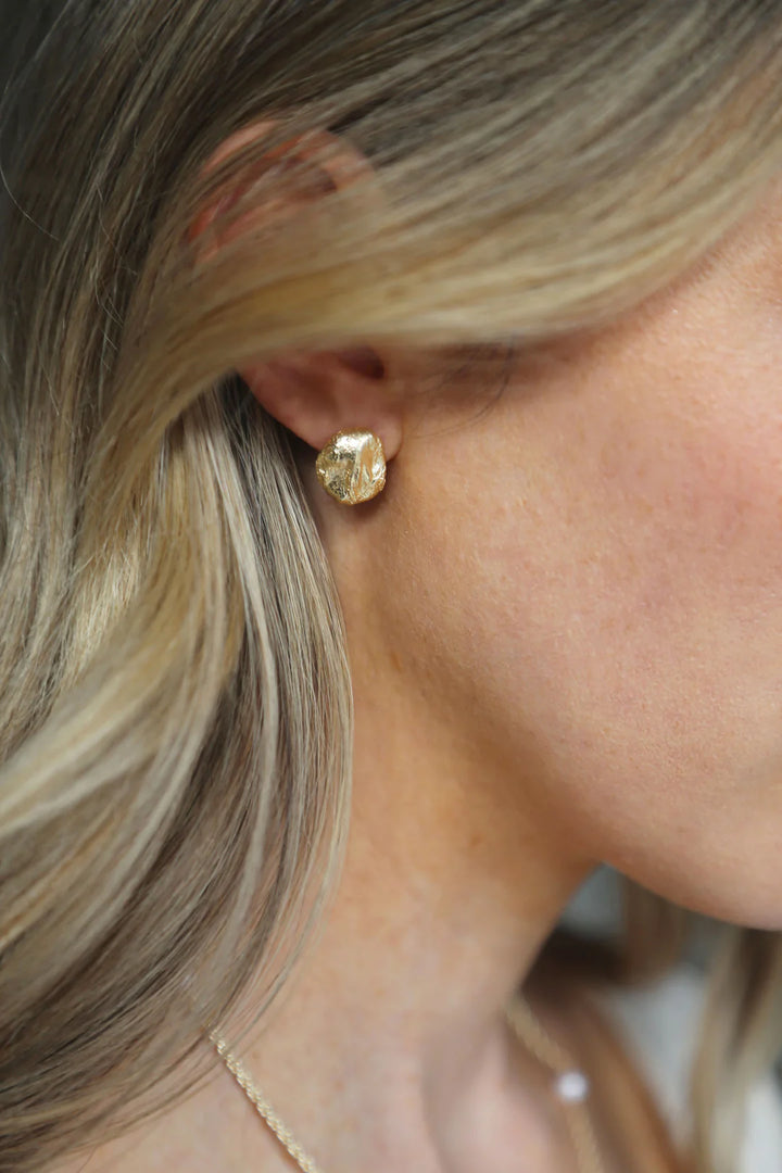 Gold Revel Earrings by Tutti &amp; Co featuring elegant design, displayed on a neutral background with close-up detail.