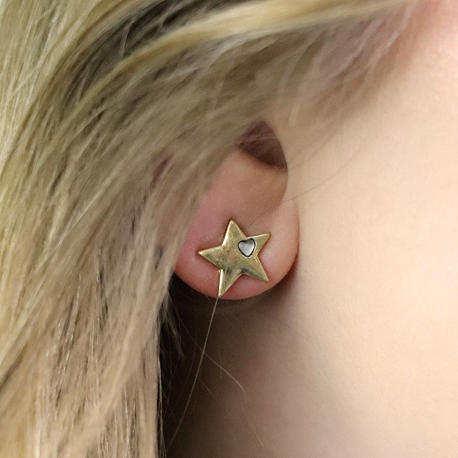 Worn gold star earrings by POM Jewellery from Cornucopia Worcester, featuring small gold star shapes on posts.