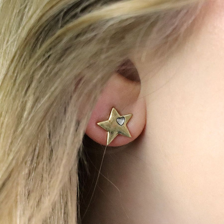 Worn gold star earrings by POM Jewellery from Cornucopia Worcester, featuring small gold star shapes on posts.