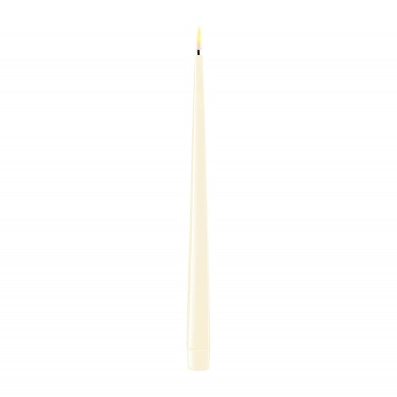 Two shiny cream LED dinner candles, 28 cm tall, from Cornucopia Home and Gift's Deluxe Home Art collection, displayed on a dinner table.
