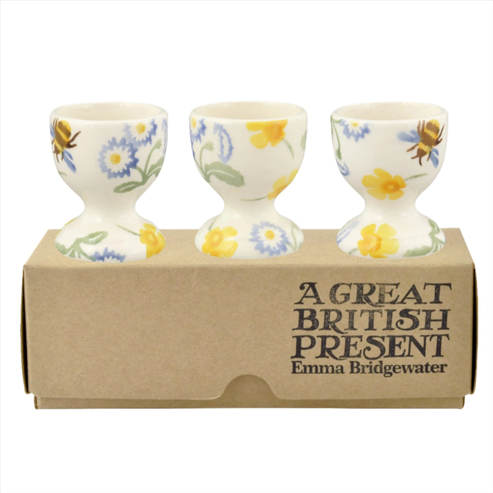 Emma Bridgewater Buttercup and Daisies set of 3 ceramic egg cups with floral pattern on white and gray backgrounds.