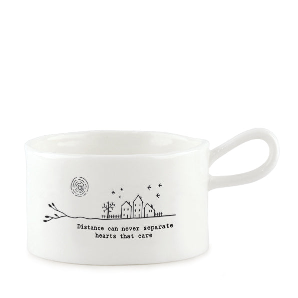 East of India porcelain tea light holder with "Distance Can Never Separate" message and a handle, perfect for cozy decor.