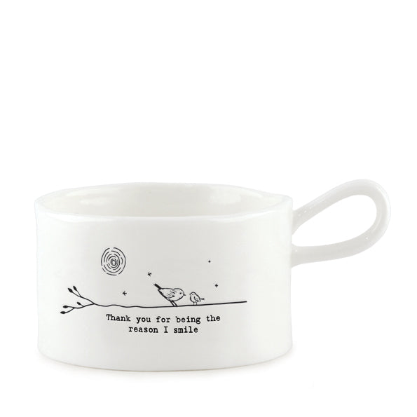 East of India porcelain tea light holder with "You Are the Reason I Smile" inscription, featuring a delicate handle and decorative design.